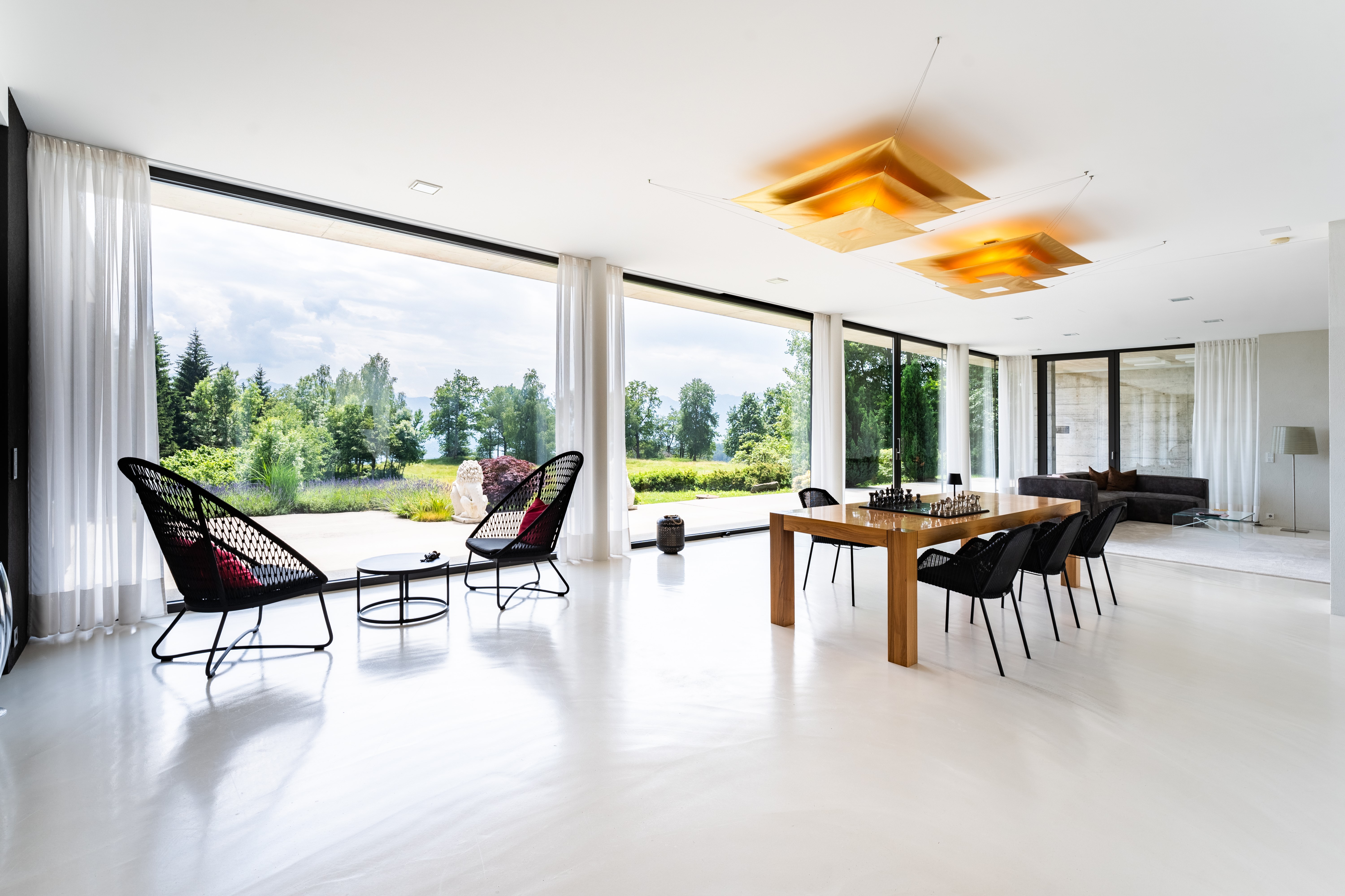 Heller Wohnsalon mit Designleuchten, Pandomo-Boden und offener Architektur