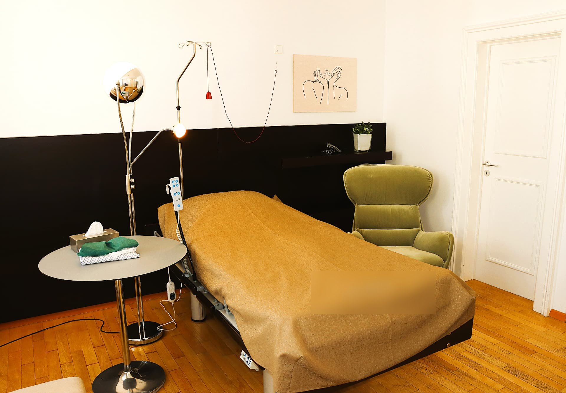 Behandlungsraum mit elektrischer Liege und Infusionsständer
